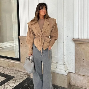 Veste mode en daim camel avec ceinture à la taille et jean gris à jambes larges tendance