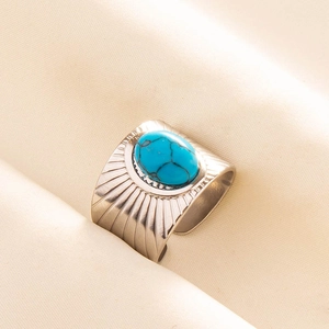 Macro shot of wide retro stainless steel ring with blue turquoise and textured radial lines