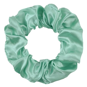 Detail of mint green satin scrunchie showing smooth silky texture and elastic folds