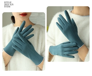 Detail of dark cyan thermal gloves with white stitching and floral lining on the cuffs
