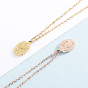 Macro detail of gold-plated 18k Miraculous Medal pendant on stainless steel necklace