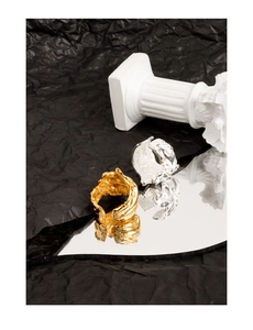 Artistic close-up of gold and silver rings with irregular textured surface and reflections