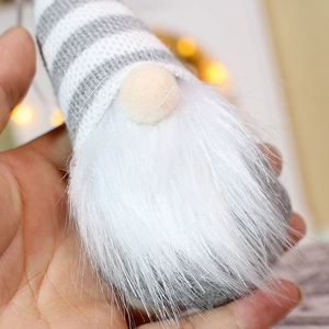 Close-up of a handmade knitted gnome ornament with gray stripes and soft white beard