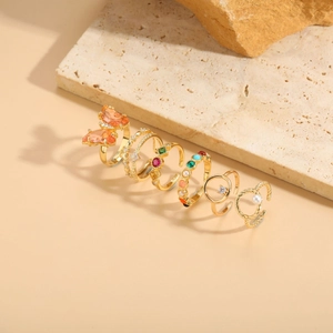 Detailed view of 7-piece gold ring set featuring butterfly and colorful gemstones