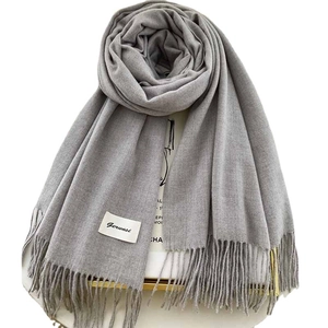 Solid grey cashmere scarf with elegant fringe trim and brand tag, classic flat lay view