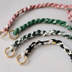 Close-up of stylish scarf handle straps with floral patterns and golden metal ring clasps