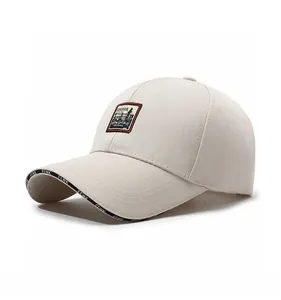 Détail d'une casquette beige avec broderie de montagne et lettrage sur le bord
