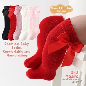 Detailed close-up of soft combed cotton knee-high baby socks with satin bow accents