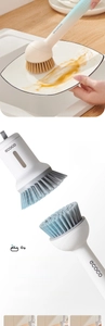 Detail of high-density PET bristles on a long-handle kitchen brush cleaning a ceramic plate