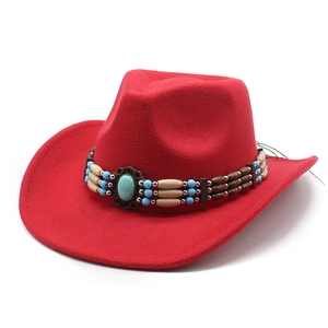 Détail d'un chapeau de cow-boy en feutre rouge avec bandeau perlé et pierre turquoise