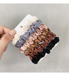 Detail of 6-pack satin scrunchies in assorted colors on display card for hair styling