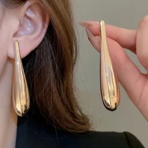 Elegant gold-tone metallic teardrop earrings with a high-polished mirror finish