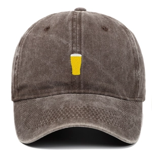 Détail de la broderie de chope de bière jaune sur casquette en coton délavé