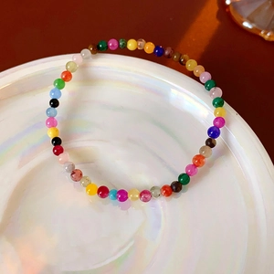 Close-up of colorful round gemstone beaded bracelet on an iridescent shell tray