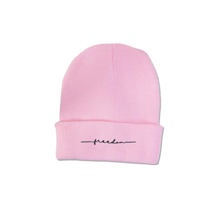 Gros plan du bonnet en tricot rose montrant la texture côtelée et la broderie freedom