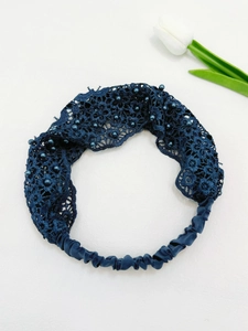Detail of dark blue lace headband with pearl beads and elastic band on white background