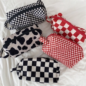Retro velvet makeup bags in checkered and cow prints with zipper closure and handle