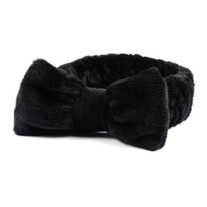 Detail van zachte zwarte koraalvlies hoofdband met strik voor gezichtsreiniging en make-up