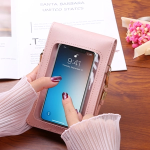 Pink faux leather touchscreen crossbody phone bag with adjustable strap on wooden table
