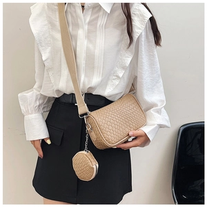 Detail of woven texture beige crossbody bag with adjustable strap and small round pouch
