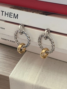 S925 sterling silver twist hoop earrings with gold contrast ring on a book edge