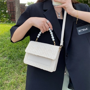 Minimalist straw woven square bag with pearl handle and leather detail for summer beach