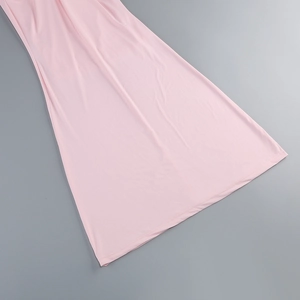 Dettaglio dell'orlo dell'abito rosa in maglia morbida con eleganti pieghe drappeggiate