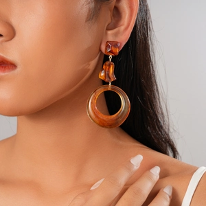 Detail of amber resin geometric drop earrings with three-stage round and square design