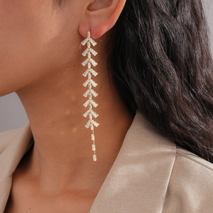 Detailed view of luxury leaf-shaped tassel earrings with zircon on a fashion model
