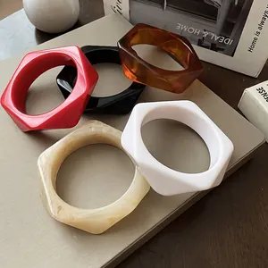 Set of five irregular hexagonal resin bangles in red, amber, black, and cream colors