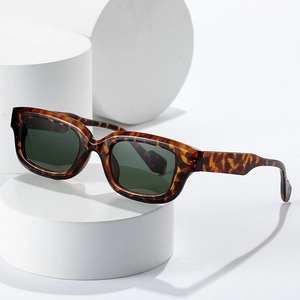 Retro square tortoiseshell sunglasses with dark resin lenses on white minimalist stand