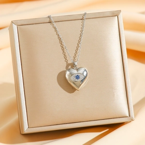 Vintage stainless steel locket necklace with heart evil eye pendant on jewelry box
