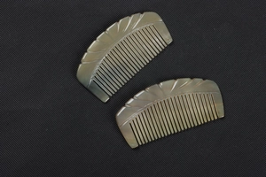 Macro view of hand-carved leaf patterns on natural translucent yak horn combs