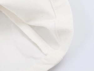 Gros plan des coutures contrastées et du tissu en coton blanc de haute qualité du top