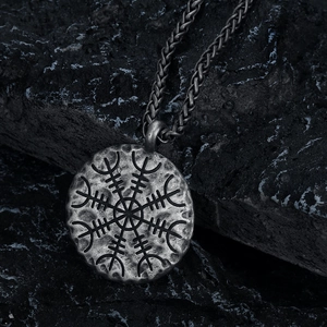 Vintage Nordic Viking Vegvisir compass pendant necklace on a rugged stone background