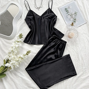 Ensemble pyjama en satin noir avec caraco et pantalon présenté avec des accessoires