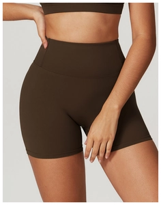 Detail of high-waisted yoga shorts in chocolate brown featuring wide tummy control waistband