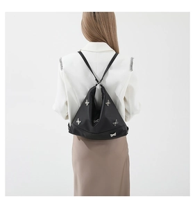 Close-up of black nylon shoulder bag with silver butterfly patterns worn by a model