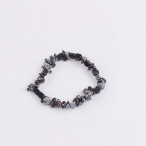 Macro detail of snowflake obsidian irregular stone beads on a stretch bracelet