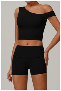Détail d'un crop top noir à une épaule et d'un short de fitness en tissu extensible