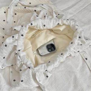 Detail of canvas tote bag interior showing a small zipper pocket and floral pattern