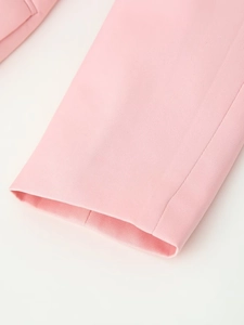 Close-up of pink woven blazer cuff with fine stitching and smooth fabric texture