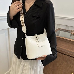 Minimalist white leather bucket bag with jacquard strap and gold hardware