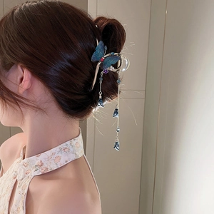 Detail of blue butterfly hair claw with long tassel pendant on elegant updo hairstyle