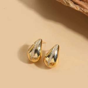 Macro shot of gold teardrop earrings featuring a centered row of white zircon accents