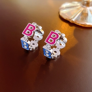 Close-up of pink and blue enamel letter B earrings with sparkling zircon inlay details