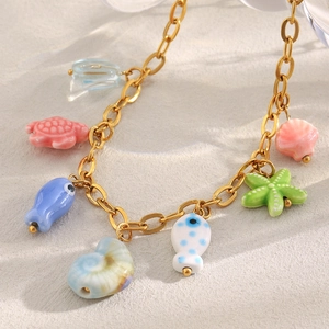 Detailed close-up of 18K gold plated chain with colorful ceramic fish and sea turtle charms