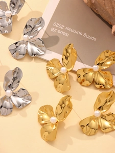 Detailansicht der kunstvollen Metallblütenohrringe mit Perle in Gold und Silber-Optik