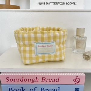 Close-up of yellow checkered quilted storage basket with heart patterns and soft fabric texture