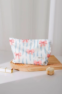 Dettaglio della borsa per il trucco in cotone con strisce blu e fiocchi rosa